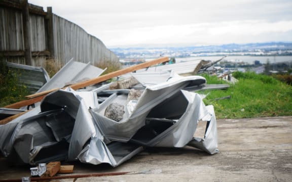 The roof of an unoccupied home in the Auckland suburb of Hillsborough came off in high winds and scattered debris down the road.
