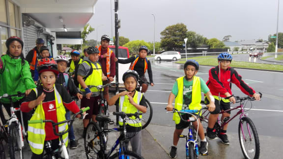A group of kids in Hi-Viz vests with bikes