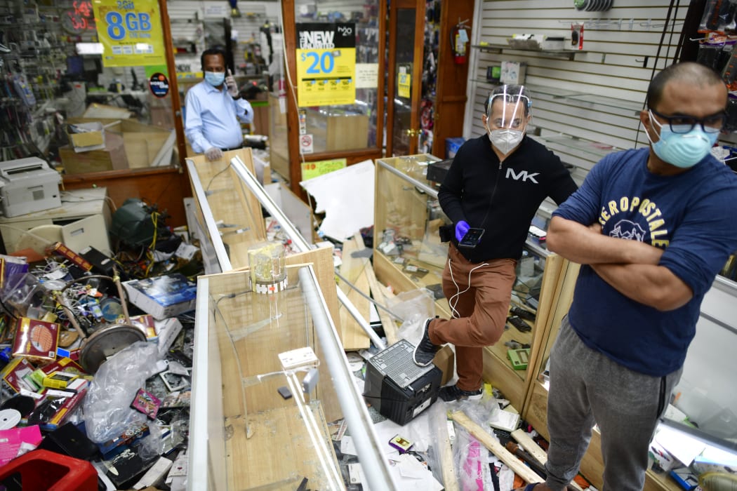 Shop owners in Philadelphia survey the damage to their store in the aftermath of widespread unrest following the death of George Floyd, 1 June 2020.