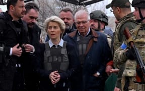 Slovakia's Prime Minister Eduard Heger (L) stands next to European Commission President Ursula von der Leyen, and European Union High Representative for Foreign Affairs and Security Policy Josep Borrell as they visit a mass grave in the town of Bucha, northwest of Kyiv on 8 April 2022.