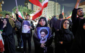 A mourner holds a picture of Iran’s supreme leader Ali Khamenei at a memorial vigil, a day after his assassination in joint US and Israeli strikes, in Tehran on March 1, 2026. The United States and Israel launched strikes against Iran on February 28, killing Iran's supreme leader and top military leaders, prompting authorities to retaliate with strikes on Israel and US bases across the Gulf. (Photo by AFP)