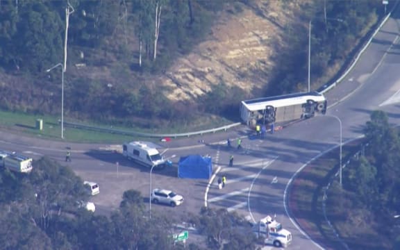This frame grab taken from video footage provided by Australian Broadcast Corporation (ABC) on June 12, 2023 via AFPTV shows the site of a bus crash, where 10 people from a wedding party were killed, in Cessnock, in Australia's Hunter wine region north of Sydney. A wedding party bus crash killed 10 people in Australia's Hunter wine region north of Sydney, police said on June 12, announcing the arrest of the 58-year-old driver. (Photo by various sources / AFP) / Australia OUT / RESTRICTED TO EDITORIAL USE - MANDATORY CREDIT "AFP PHOTO / ABC" - NO MARKETING - NO ADVERTISING CAMPAIGNS - DISTRIBUTED AS A SERVICE TO CLIENTS