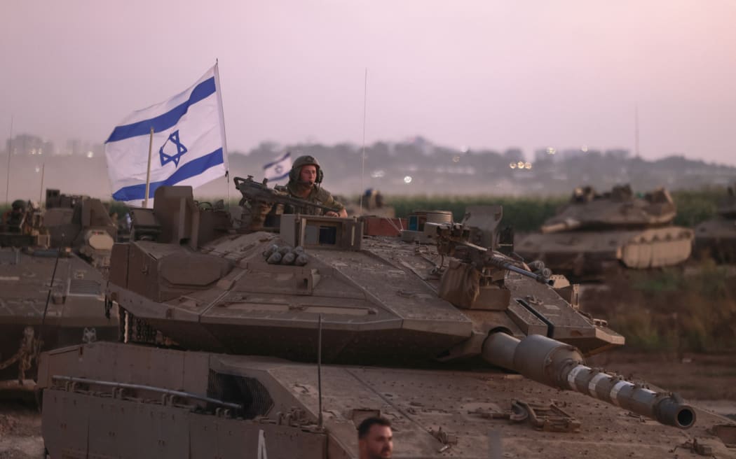 A convoy of Israeli armoured vehicles advances near the border with Gaza on October 12, 2023. Thousands of people, both Israeli and Palestinian, have died since October 7, after Palestinian Hamas militants entered Israel in a surprise attack leading Israel to declare war on Hamas in the Gaza Strip enclave. (Photo by Menahem KAHANA / AFP)