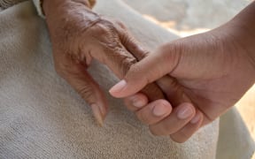 Close up granddaughter takes care of the health sick grandmother at home by holding hands. Lifestyle support the love of the family.