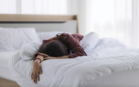 Asian woman is sleeping as a hangover from a party or asleep from exhaustion in her bed in the bedroom until the morning.