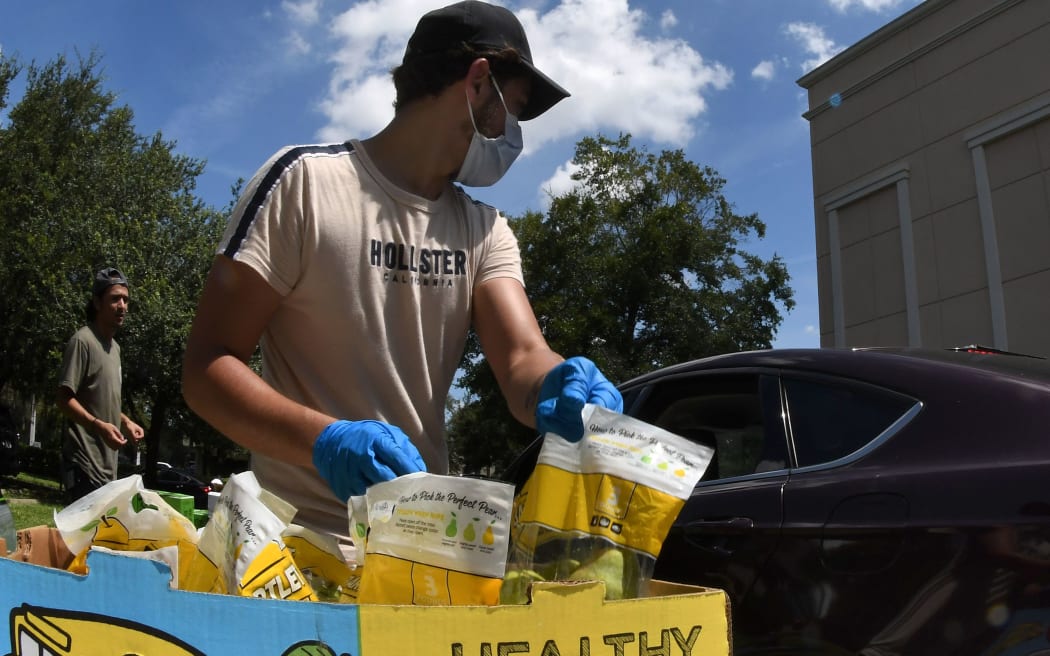 Volunteers distribute food from the Second Harvest Food Bank of Central Florida to the needy at Church in the Son on August 7, 2020 in Orlando, Florida.
