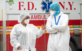 Bronx-Lebanon Hospital Center medical staff speak to each other outside of the emergency room bay in New York City.