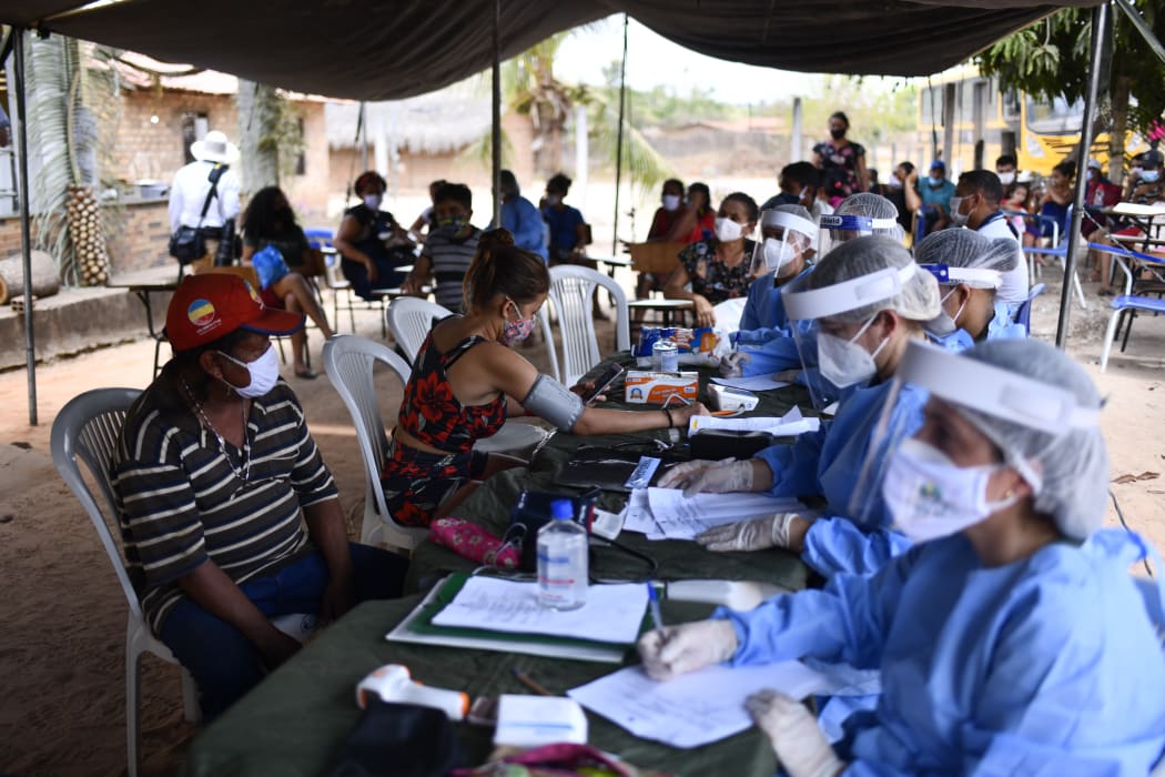 Member of the medical team of the Armed Forces of Brazil examines a man of the Guajajara indigenous ethnicity during the Covid-19 pandemic on 3 October, 2020.