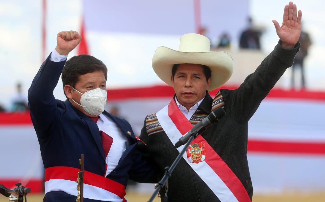 This handout picture released by the Peruvian presidency shows Peru's new Prime Minister Guido Bellido (R) and Peruvian President Pedro Castillo greeting their supporters during the symbolic presidential investiture ceremony at Pampa de la Quinua in Ayacucho, southern Peru, on July 29, 2021.