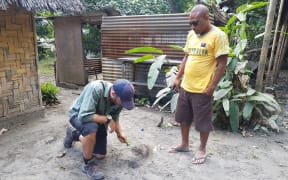 Graham Leonard sampling thick ashfall in Ambae, Vanuatu in 2018, at the home of a local resident.