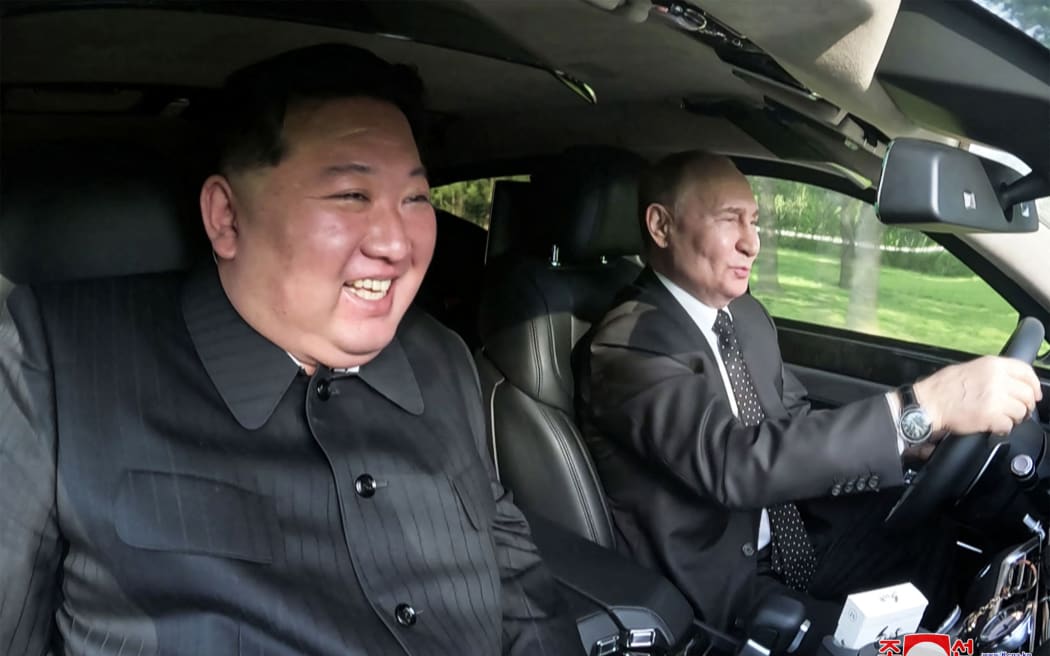 这张照片拍摄于 2024 年 6 月 19 日，并于 2024 年 6 月 20 日由朝鲜官方的朝鲜中央通讯社 (KCNA) 通过 KNS 发布，照片显示朝鲜领导人金正恩 (左) 坐在俄罗斯总统弗拉基米尔·普京 (右) 驾驶的汽车副驾驶座上，车位于平壤锦绣山国宾馆的花园中。 (照片由 KCNA 通过 KNS / AFP 提供)/ 韩国 OUT / --- 编者注--- 仅限编辑使用 - 必须注明出处 