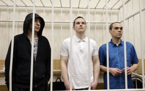 The three lawyers who used to represent the late opposition leader Alexei Navalny: Igor Sergunin, Alexei Liptser and Vadim Kobzev (L-R in the defendants' cage), accused of participating in an "extremist" organisation, attend their verdicts reading in the town of Petushki in the Vladimir region on January 17, 2025. (Photo by TATYANA MAKEYEVA / AFP)