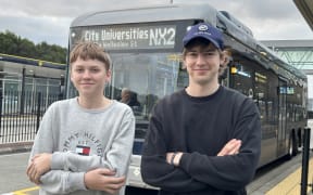 A photo of George and Robert Richards standing in front of the NX2 bus.