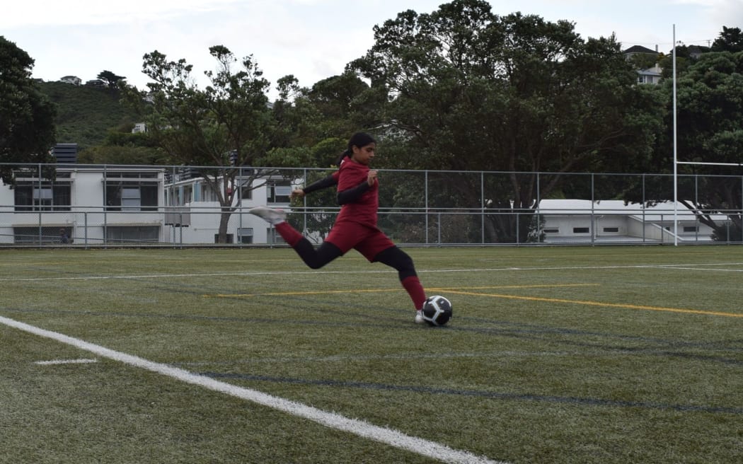 A young girl playing football.