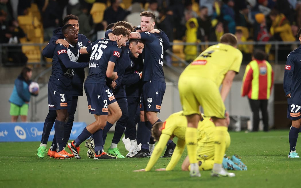 The Phoenix sit dejected after their loss as Melbourne celebrate during the A-League Men’s Semi Final 1 (2nd leg) - Wellington Phoenix v Melbourne  Victory FC at Sky Stadium, Wellington on the 18th May 2024.