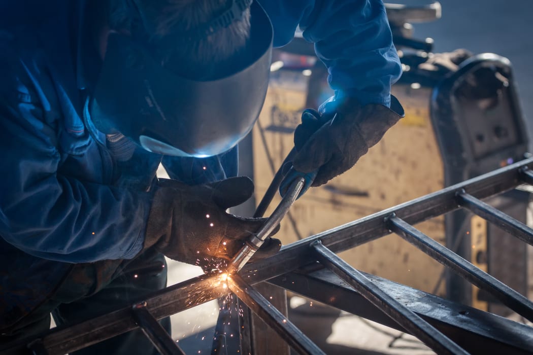worker with protective mask welding metal
