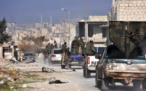 Syrian pro-government forces patrol Aleppo's Sheikh Saeed district, on 12 December, 2016, after troops retook the area from rebel fighters.