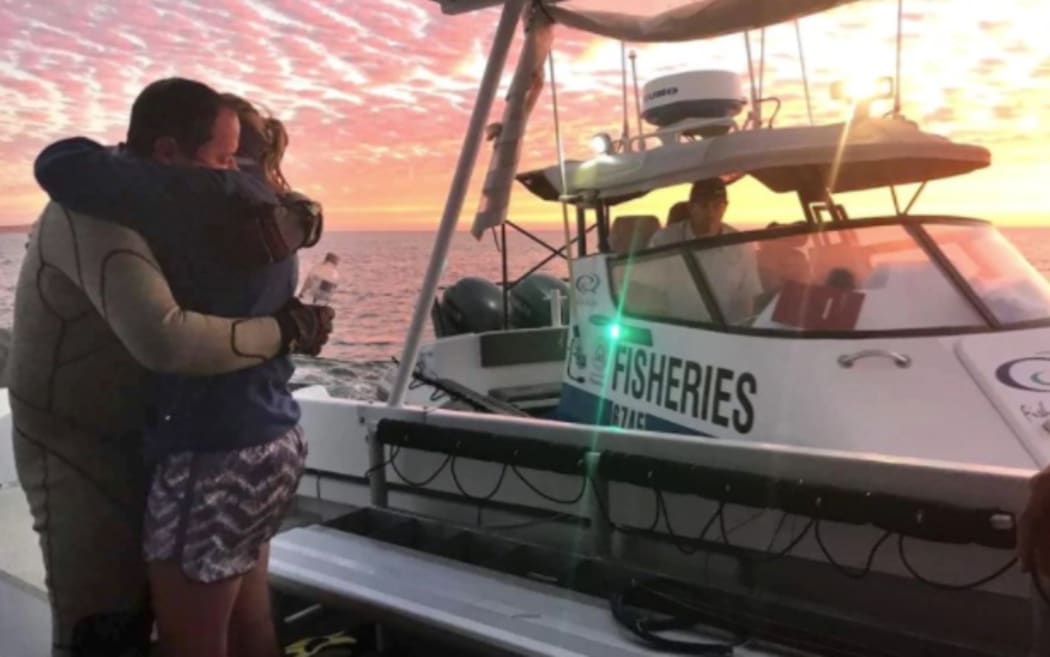 John Craig embraces his wife after being followed by a shark and swimming to safety.