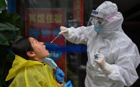 A medical worker takes a swab sample from a person to be tested for the COVID-19 novel coronavirus in Wuhan, China's central Hubei province on March 29, 2020, a day after travel restrictions into the city were eased following the outbreak.