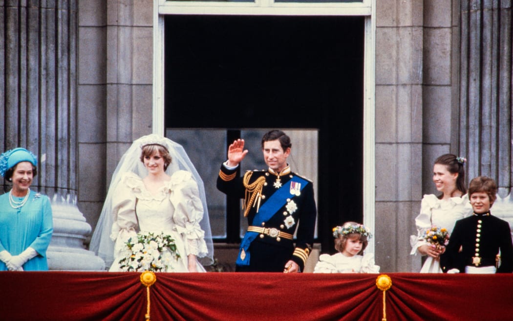 Charles, Prince of Wales, acknowledges the crowd with his bride, Lady Diana, on the balcony of Buckingham Palace with members of the royal family on July 29, 1981, after their wedding in St Paul's Cathedral. (Photo by POOL / AFP)