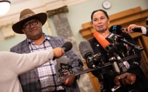 Māori Party Co-leaders, Rawiri Waititi (Left) and Debbie Ngawera-Packer (Right) photographed standing talking to media in the Parliamentary press gallery.