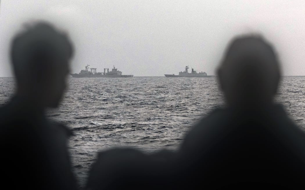 This handout photo taken on February 13, 2025 and released by The Australian Defence Force shows sailors onboard the Royal Australian Navy ship HMAS Arunta looking at the People's Liberation Army-Navy (PLA-N) Fuchi-class replenishment vessel and Weishanhu Jiangkai-class frigate Hengyang in the Tasman Sea. Australia's foreign minister voiced concern on February 21 over live fire drills conducted by three Chinese warships sailing off the country's east coast. (Photo by Handout / AUSTRALIAN DEFENCE FORCE / AFP) / RESTRICTED TO EDITORIAL USE - MANDATORY CREDIT "AFP PHOTO /  AUSTRALIAN DEFENCE FORCE" - NO MARKETING NO ADVERTISING CAMPAIGNS - DISTRIBUTED AS A SERVICE TO CLIENTS
