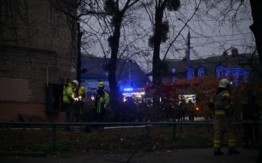 Ukrainian firefighters intervene at the scene where a Russian missile fragment fell near a residential building in the centre of the Ukrainian capital of Kyiv, causing a fire, 15 November 2022.