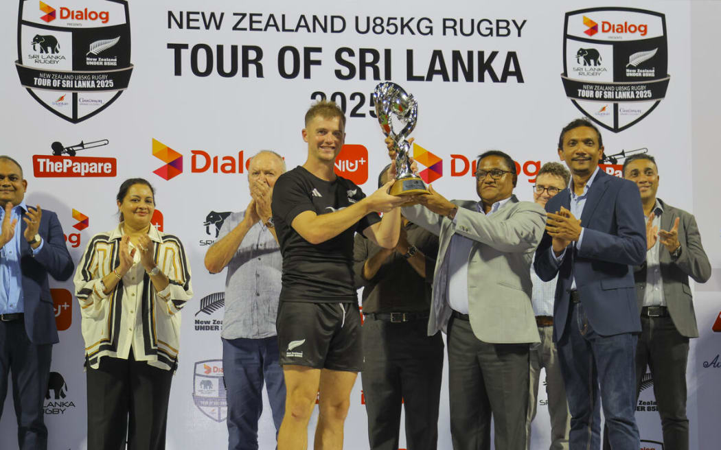 NZ U85kg Jarred Percival lifts the Sir Graham Henry Trophy.
