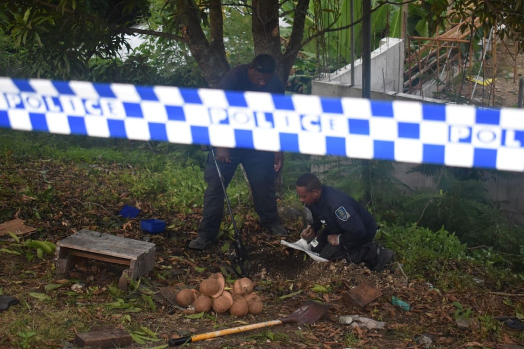Officers from the police explosive ordnance disposal team inspecting the remaining pieces of the WW2 US 105mm high explosive projectile that killed one person and injured three others in Honiara. May 2021