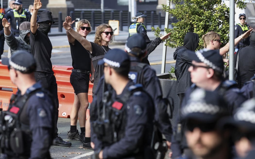Members of The National Socialist Network attend a Stop Immigration Rally outside of Parliament House in Melbourne on May 13, 2023. (Photo by Martin KEEP / AFP)