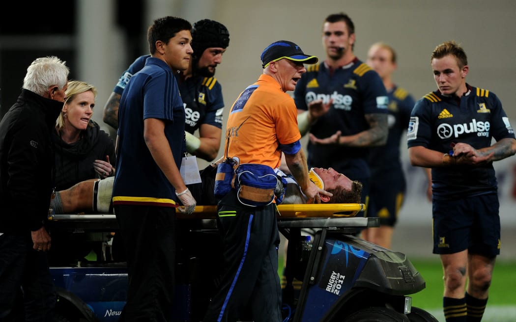 Angus Cottrell of the Force is assisted by medical staff of the field in Dunedin.