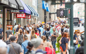NEW YORK, USA - AUGUST 28, 2014: Crowded sidewalk on 5th Avenue with tourists and commuters on a sunny day.