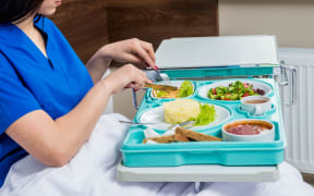 Tray with breakfast for the young female patient. The young woman eating in the hospital. Hospital food concept