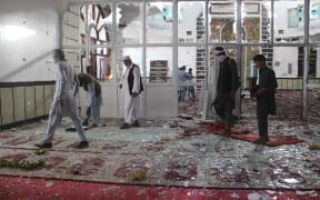 Afghan residents walk inside a damaged mosque after a suicide attack during Friday prayers in Gardez of Paktia province.