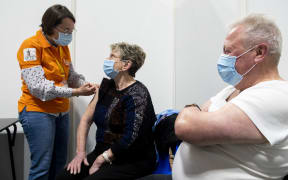 A caregiver giving an intramuscular injection of PFIZER vaccine during a mass vaccination campaign at gayant expo in Douai in France.