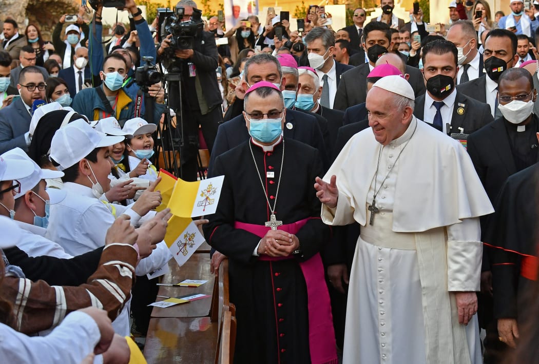 Pope Francis is greeted by children on his arrival at a Baghdad cathedral on the second day of the first papal visit to Iraq. Pope Francis made a plea for peace, telling those gathered at an interreligious service he hoped the world would "journey from conflict to unity."