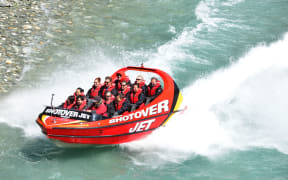 Tourists enjoy a high-speed boat ride on Queenstown