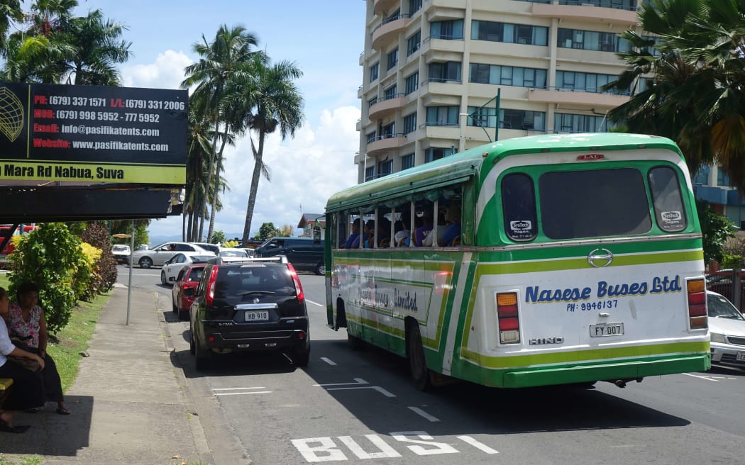 A bus passes a stop in downtown Suva, Fiji.