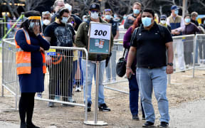 People wait in a queue for their Covid-19 coronavirus vaccination in Sydney on August 18, 2021. (Photo by Saeed KHAN / AFP)