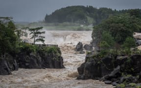 Raging waters flow along the Sendai River in the wake of Typhoon Nanmadol in Isa, Kagoshima prefecture on 19 September, 2022.