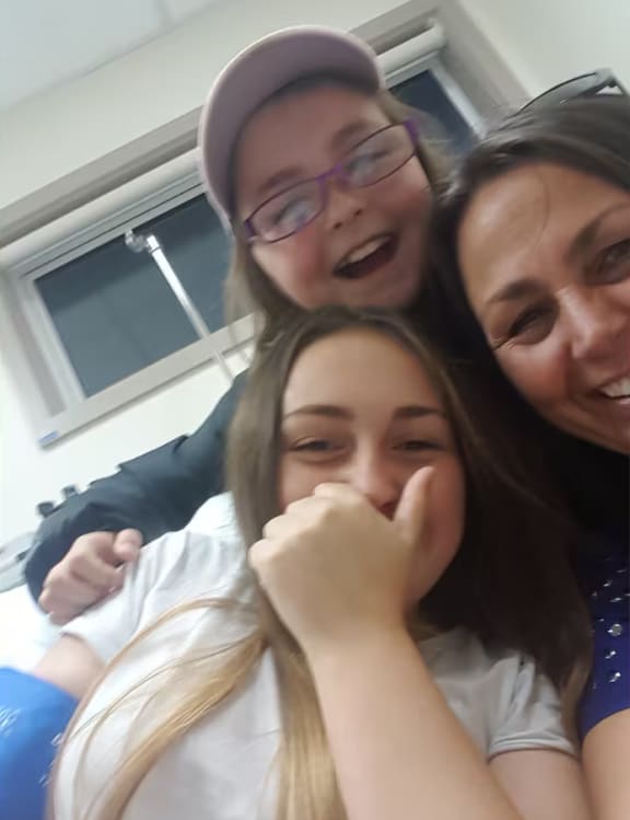 Tayla, with her mother and sister, recovering in hospital after an earlier incident where she'd suffered a similar asthma attack, but the ambulance arrived in time.