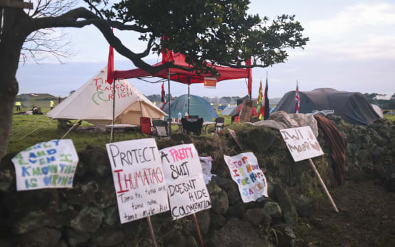 Protest signs and tents at Ihumātao.