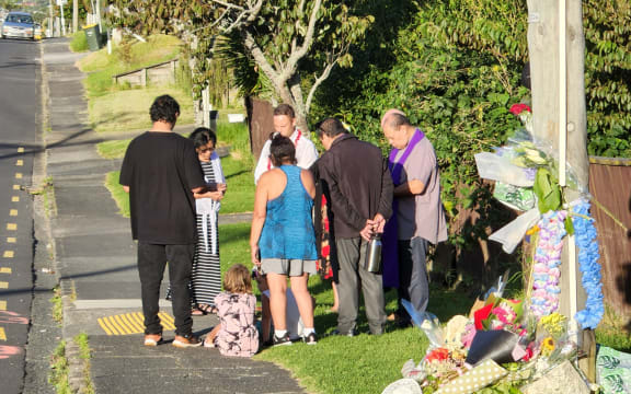 A pastor and a group of friends and locals say prayers on Sunday following the death of Joshuah Tasi, 28, on Friday night.