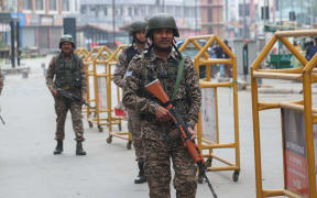 Indian paramilitary soldiers patrol along a street in Srinagar, Jammu and Kashmir, on May 8, 2025. Indian and Pakistani soldiers exchange small arms and artillery fire overnight along the Line of Control (LoC), the de facto border dividing the two sides of Kashmir, the Indian army says on May 8. Tensions between the two nuclear-armed neighbors escalate, sparking fear and uncertainty in the region. On May 7, the Indian Armed Forces launch 'Operation Sindoor', targeting alleged terrorist infrastructure in Pakistan and Pakistan-occupied Jammu and Kashmir. The Indian government states that it carries out military strikes on nine sites in Pakistan in retaliation for the deadly militant attack on tourists at the popular resort town of Pahalgam in south Kashmir on April 22, 2025, which leaves 26 tourists dead. (Photo by Firdous Nazir/NurPhoto) (Photo by Firdous Nazir / NurPhoto / NurPhoto via AFP)
