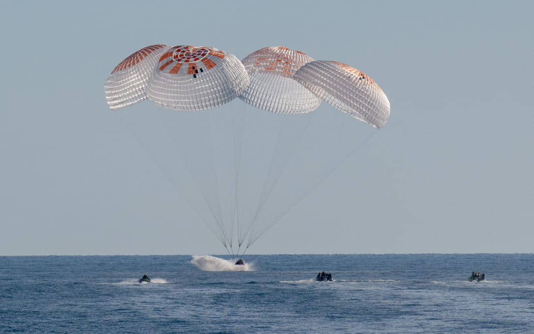 This handout picture provided by NASA shows support teams work around a SpaceX Dragon spacecraft shortly after it landed with NASA astronauts Nick Hague, Suni Williams, Butch Wilmore, and Roscosmos cosmonaut Aleksandr Gorbunov aboard in the water off the coast of Tallahassee, Florida, on March 18, 2025. (Photo by Keegan Barber / NASA / AFP) / RESTRICTED TO EDITORIAL USE - MANDATORY CREDIT "AFP PHOTO /  NASA / KEEGAN BARBER" - NO MARKETING NO ADVERTISING CAMPAIGNS - DISTRIBUTED AS A SERVICE TO CLIENTS