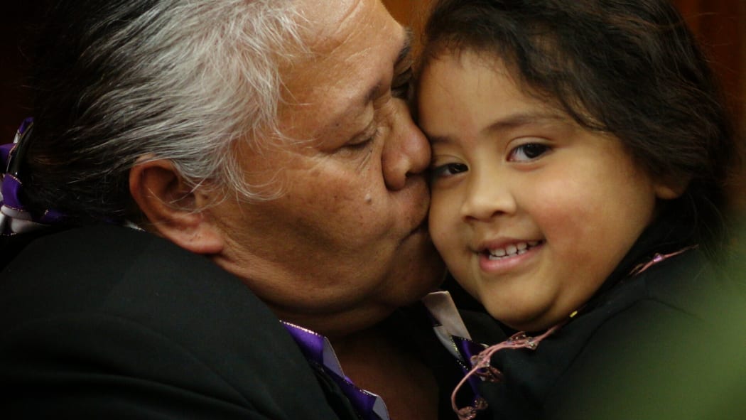 Jonah Lomu's mother, Hepi, cuddles a child after the service.