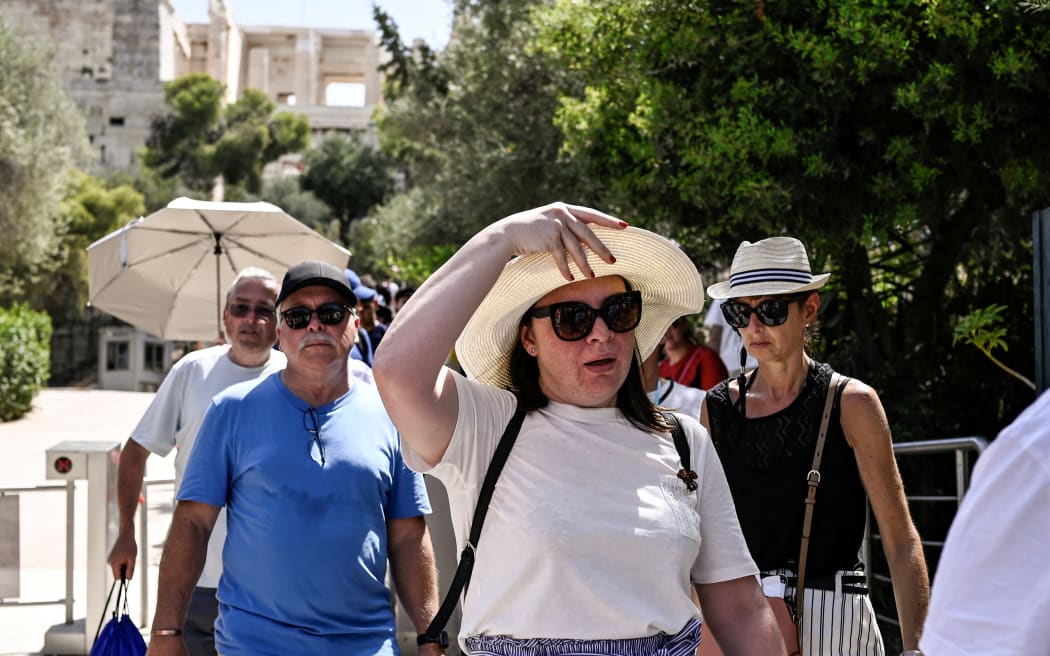 Visitors leave the Acropolis archeological site in Athens on 14 July 2023.