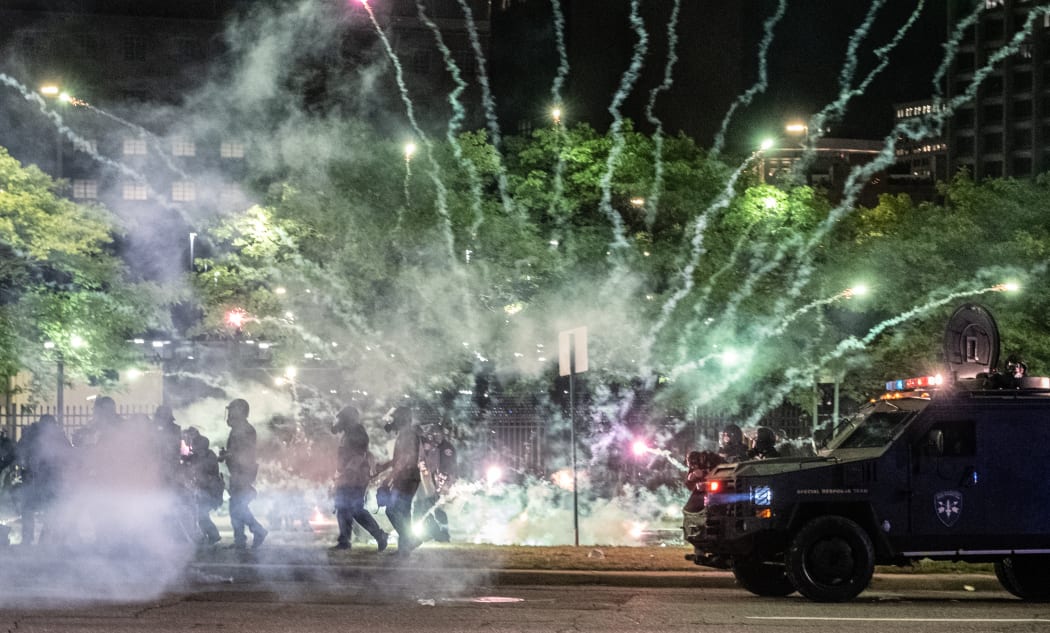 Tear gas canisters explode near some Detroit Police units who attempted to break up protesters, through the streets of Detroit, Michigan for a second night.