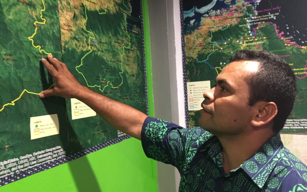 Climate change officer, George Dregaso, examines map at NDMO headquarters in Lautoka, Fiji
