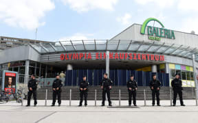 Policemen stand in front of the Olympia-Einkaufszentrum shopping centre in Munich one day after the attack.